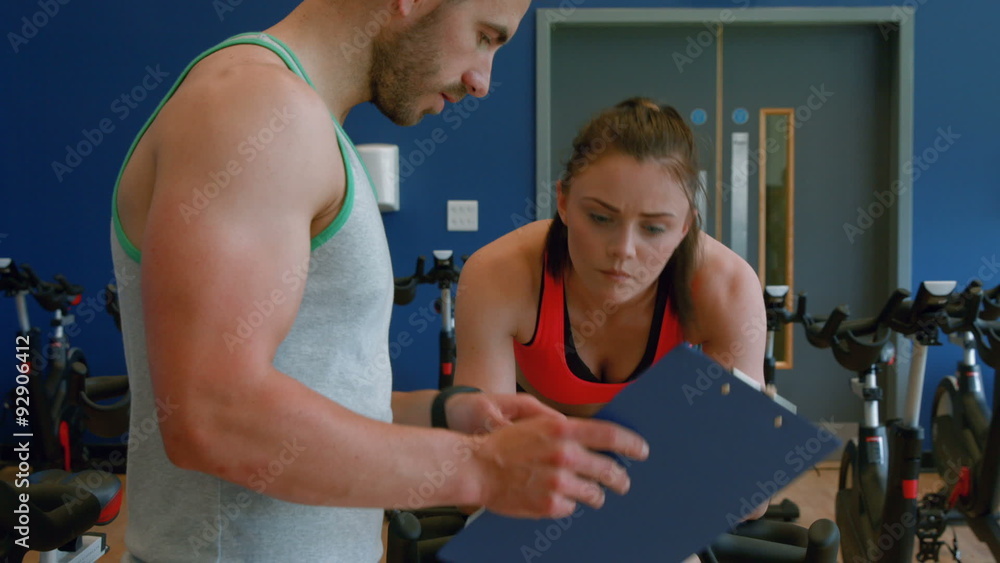 Trainer with client on exercise bike Trainer with client on exercise bike