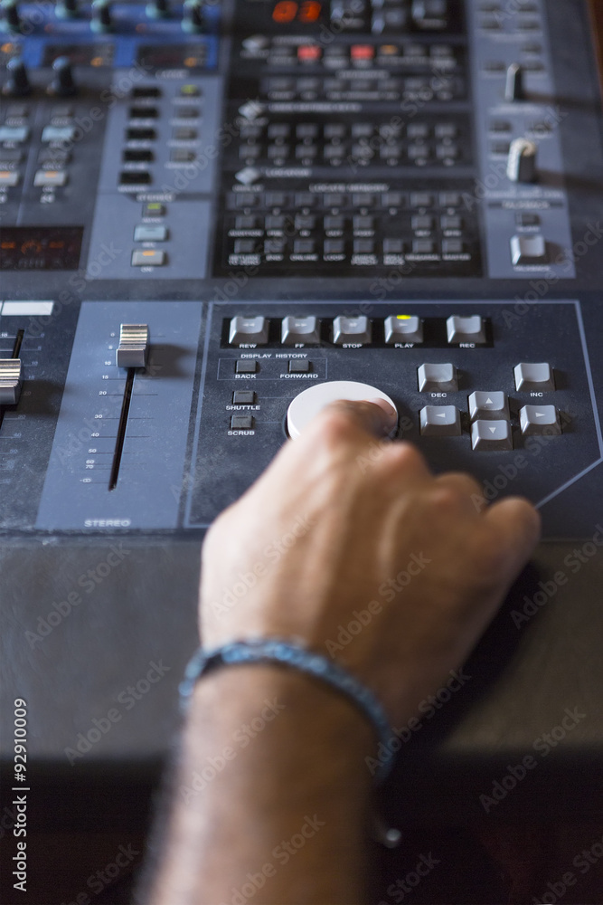 hand adjusting a sound mixing desk