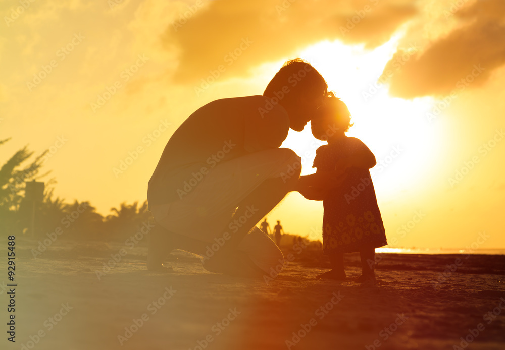 Father and little daughter silhouettes at sunset