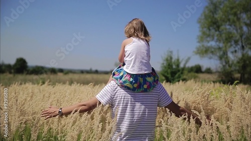 Girl is sitting on the back of dad