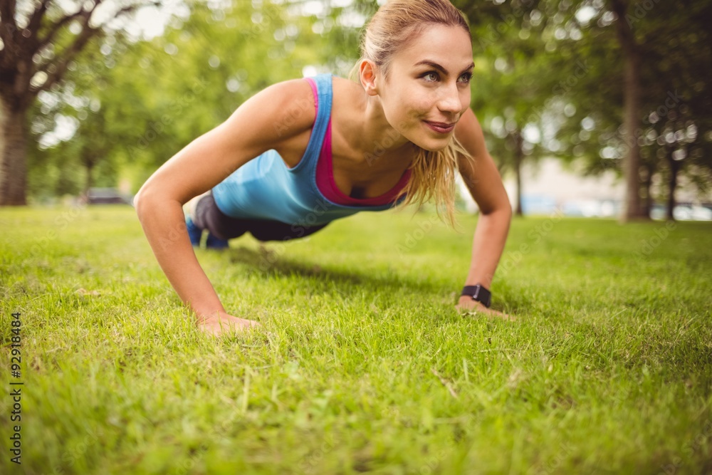 Smiling woman exercising on grass Smiling woman exercising on grass