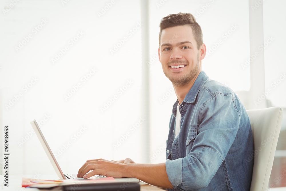 Portrait of smiling young man working on laptop Portrait of smiling young man working on laptop