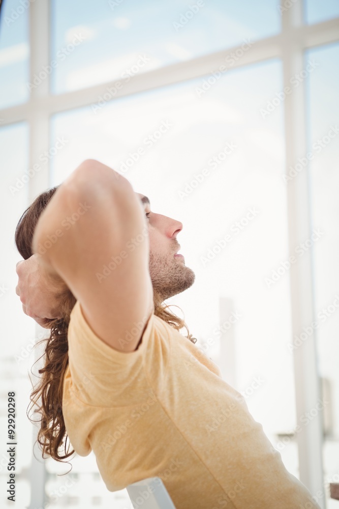 Hipster relaxing against window in office Hipster relaxing against window in office
