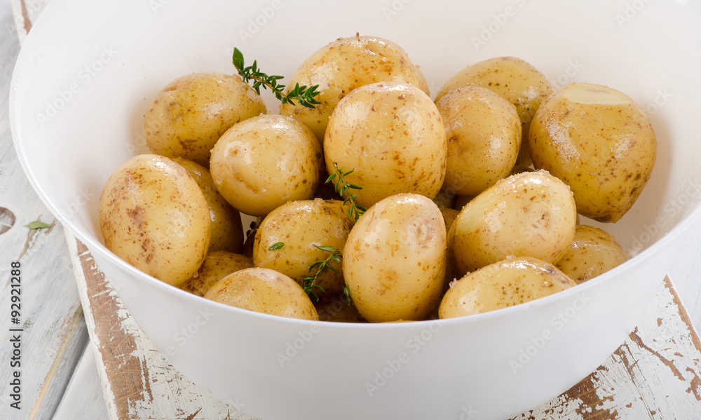 Raw potatoes with spices and oil on a white wooden board. Raw potatoes with spices and oil on a white wooden board.