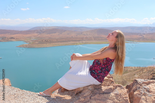 A young woman sit on the rock.    © makarova