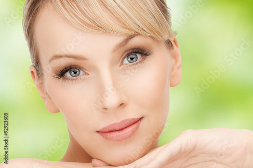beautiful young woman face over green background