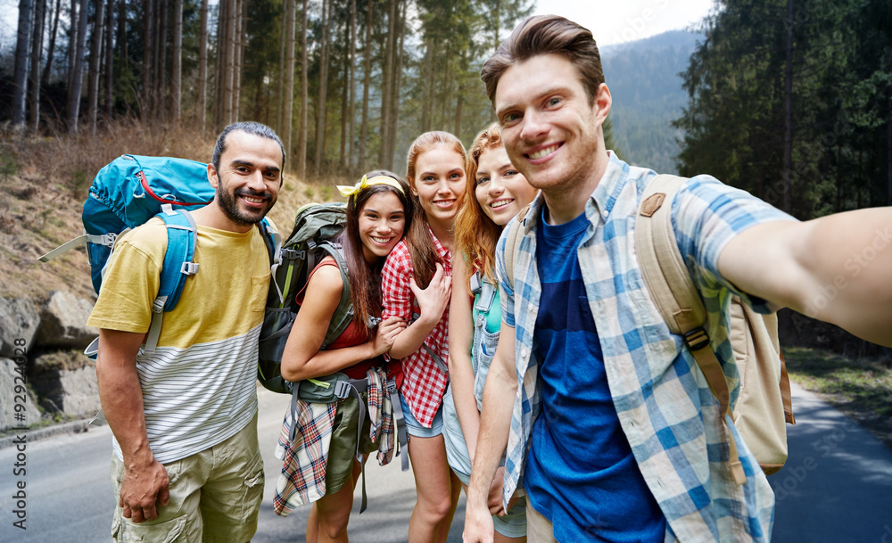 friends with backpack taking selfie in wood friends with backpack taking selfie in wood