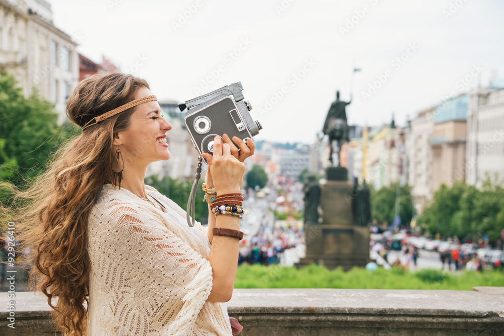 Obraz premium Joyful trendy hippie woman tourist with retro camera in Prague