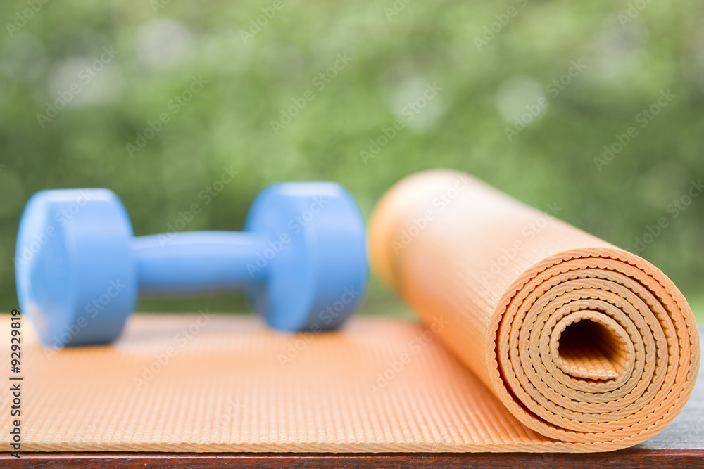 orange yoga mat and blue dumbbell orange yoga mat and blue dumbbell