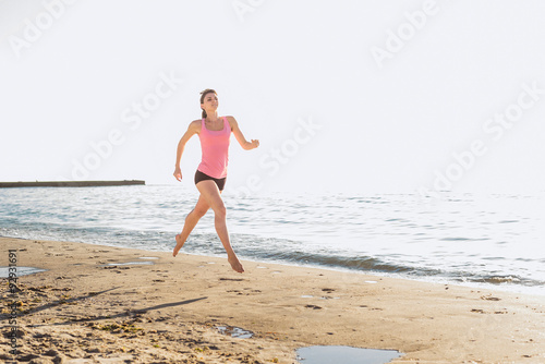 Running woman. Female runner jogging during the sunrise on beach © kurapatka