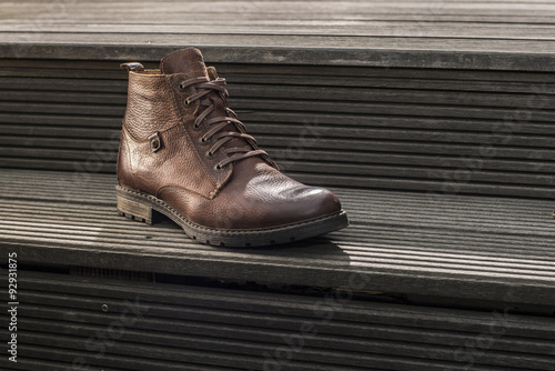 Obraz na płótnie Mens leather boot on wooden stairs w salonie