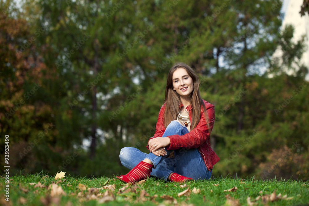 Hppy beautiful woman in red leather jacket and blue jeans sittin Hppy beautiful woman in red leather jacket and blue jeans sittin