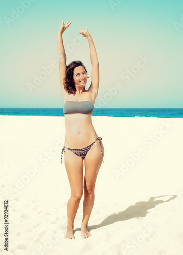 woman raised her hands up on the beach