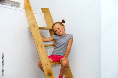 Cute little girl posing on staircase