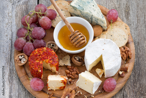 soft cheeses and snacks on a wooden background, close-up