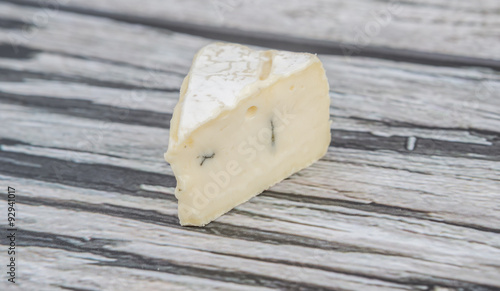 Blue cheese slices over wooden background