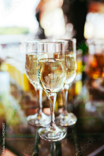 Elegant glasses with champagne standing in a row on serving tabl