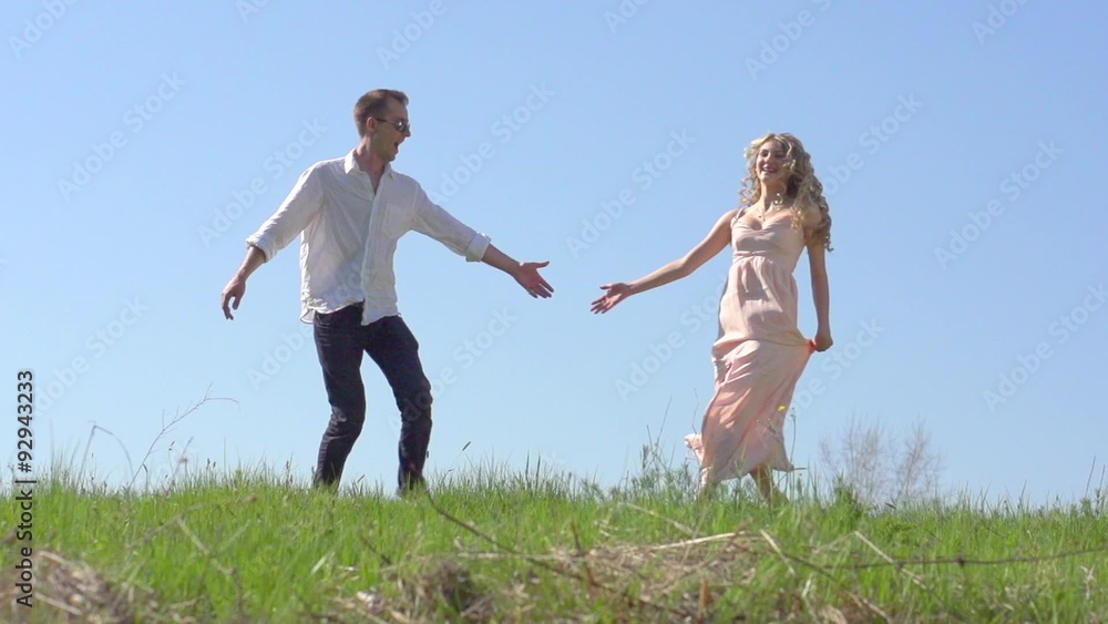 Happy couple having fun outdoor. Young man and woman spinning on summer field. Happy couple having fun outdoor. Young man and woman spinning on summer field.