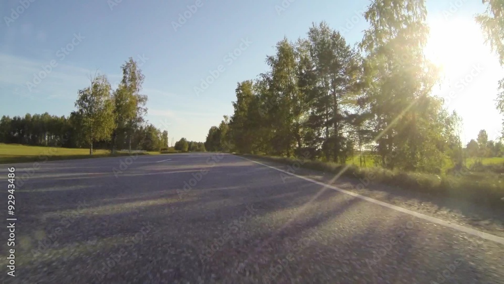 Driving on countryside highway with trees and green fields in Driving on countryside highway with trees and green fields in