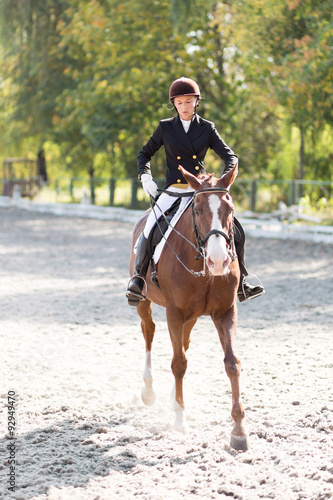 Young horse rider girl at the dressage competition