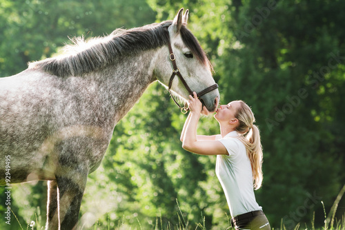 Junge Frau küsst ihr Pferd 