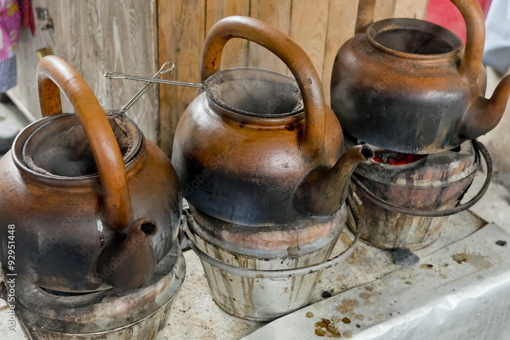 baked clay kettle with hot water on stove. baked clay kettle with hot water on stove.