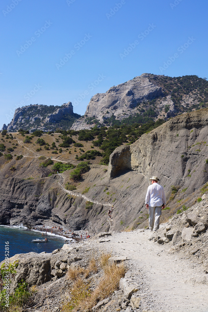 Naklejka premium Мужчина идет по тропе Голицына. Поселок Новый Свет. Крым.