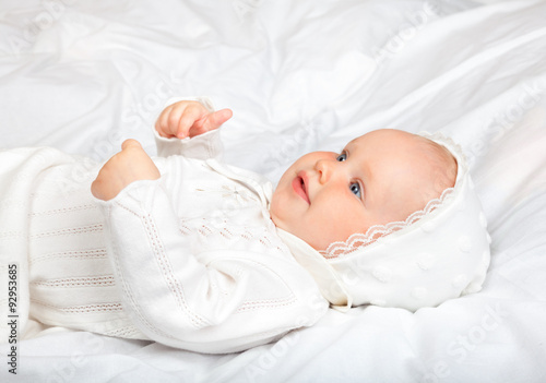 Foto Close-up shot of six month baby girl wearing white christening clothes laying on