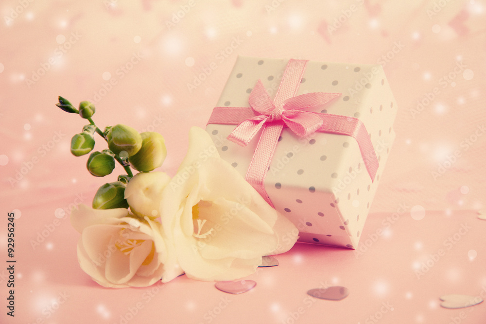 Beautiful little gift box and freesia flower on pink background Beautiful little gift box and freesia flower on pink background
