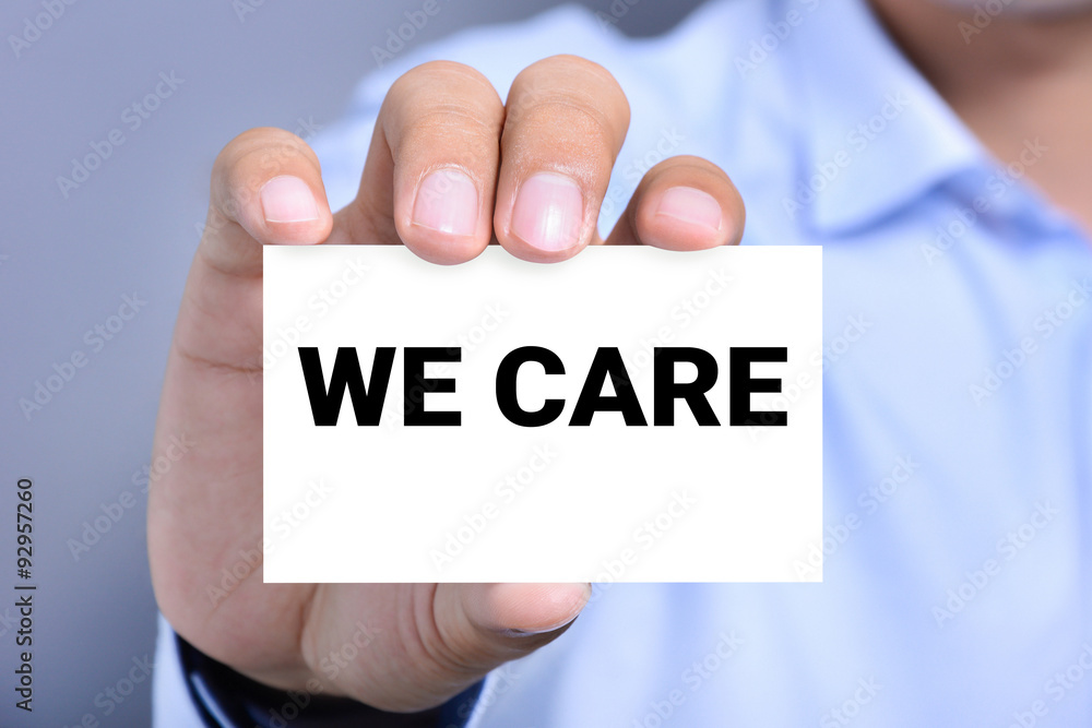 WE CARE, message on the card shown by a man WE CARE, message on the card shown by a man