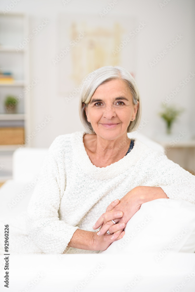 entspannte ältere frau zuhause auf dem sofa