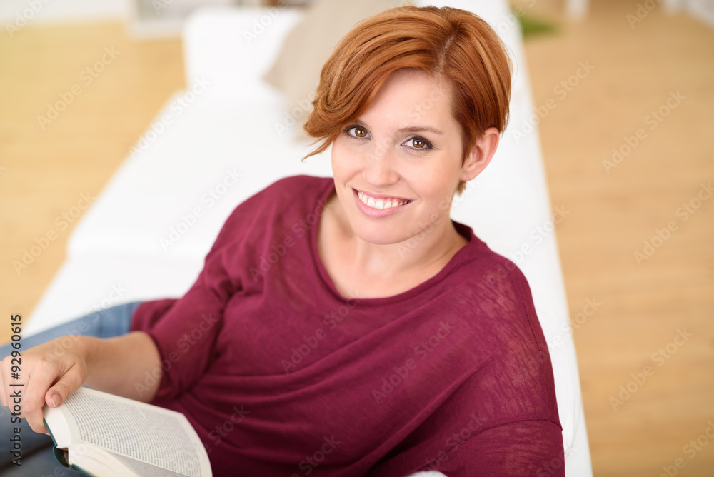 attraktive junge frau liest ein buch auf dem sofa attraktive junge frau liest ein buch auf dem sofa