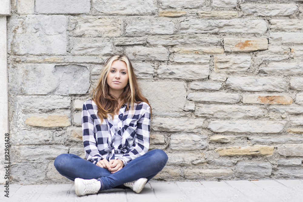 Urban girl sitting in the street and looking at camera. Urban girl sitting in the street and looking at camera.