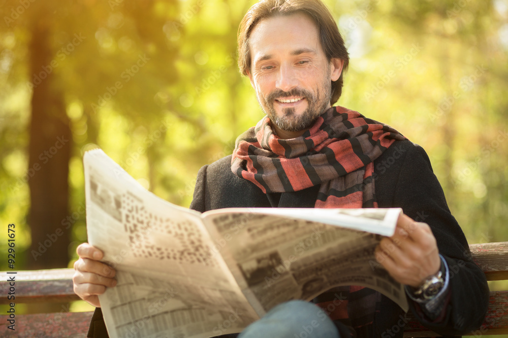 Fototapeta premium Man reading newpaper in the park