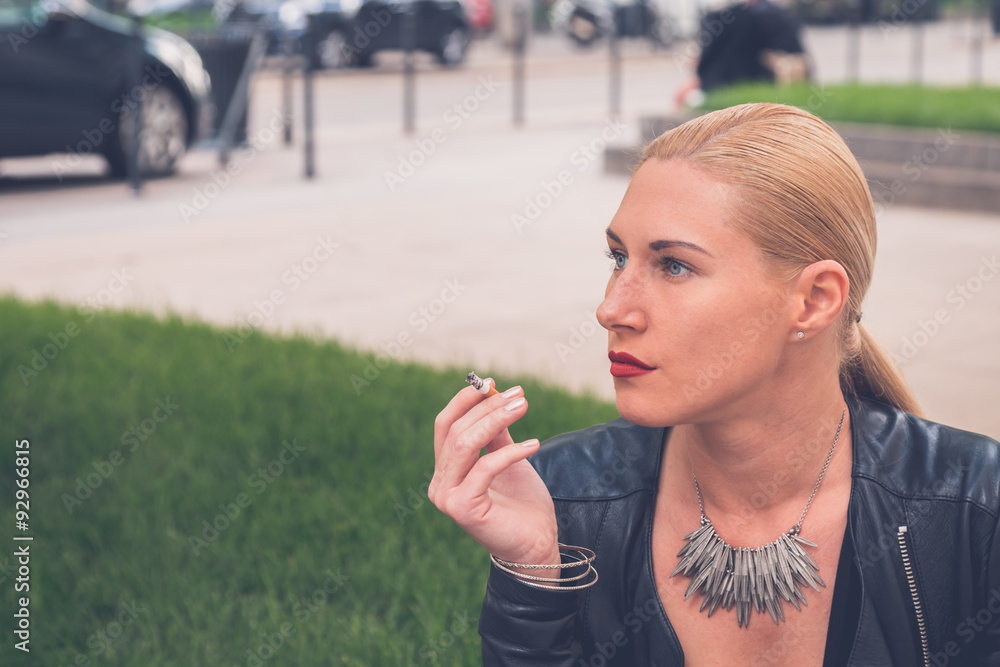 Beautiful girl smoking in the city streets