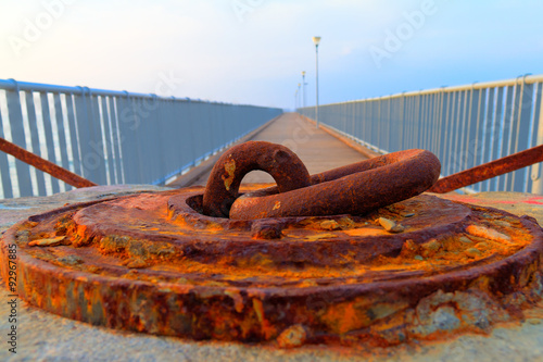 Rusted iron anchorage in afternoon light with long 