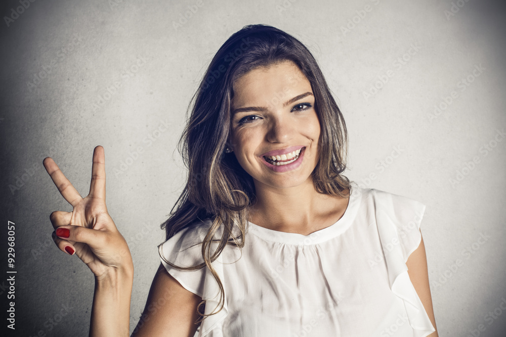 Beautiful girl showing victory gesture Beautiful girl showing victory gesture