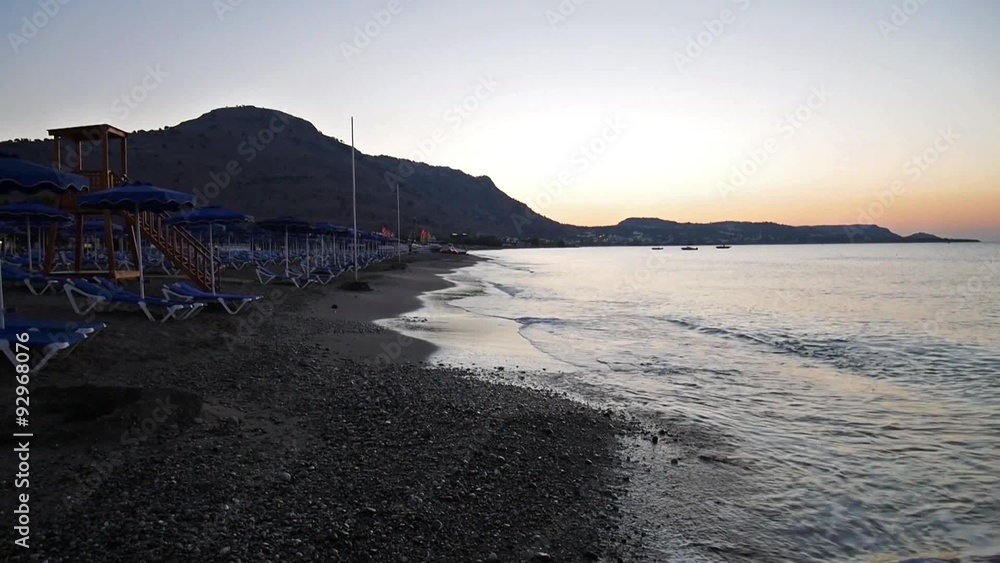 Morning sea beach with empty blue sunbeds Morning sea beach with empty blue sunbeds