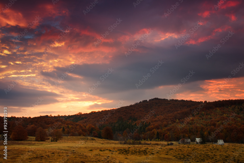 Panoramic view of the dramatic sunset in the autumn mountains.
