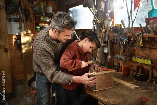 Fotografija Portrait of a middle age gray hair man with beard working with his little girl in the workshop