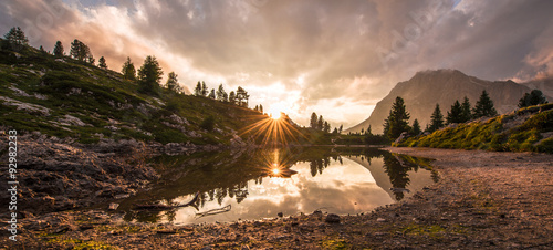 Fascinating reflections of the Dolomites mountains in lake Limedes at Sunset. Vivid and bright colors of the dramatic evening.