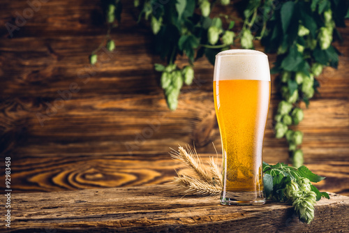 Glass of beer on old wooden table and wooden background