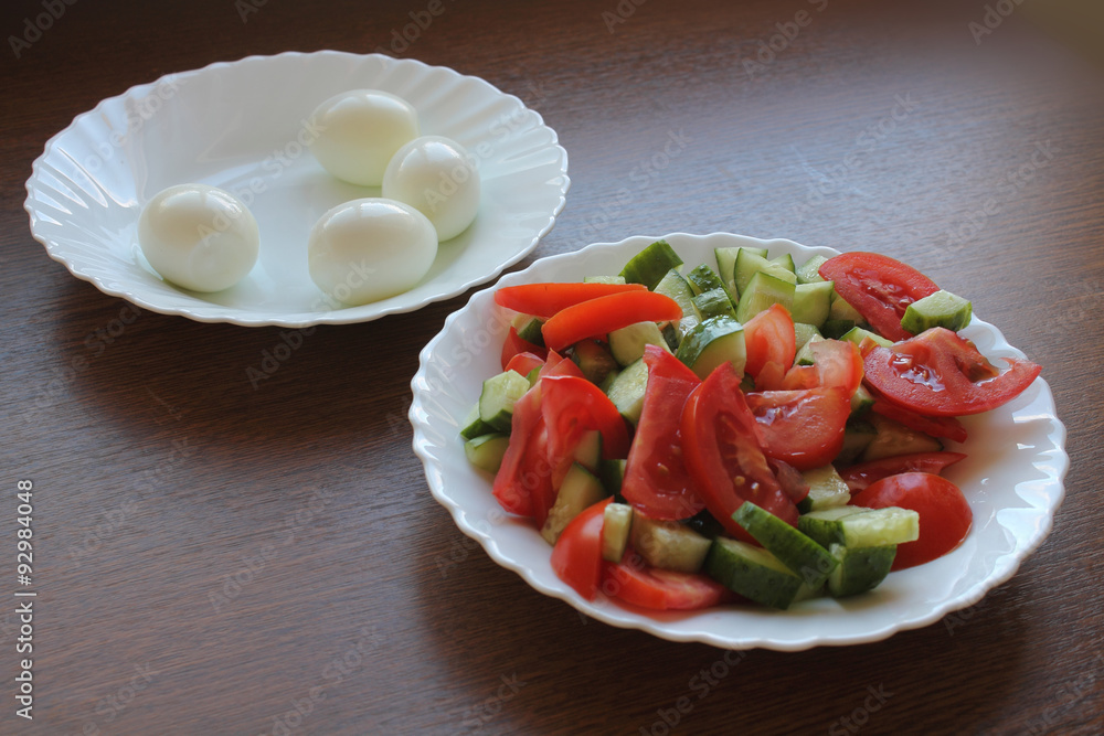 Still life. Salad with tomatoes and cucumbers on the dish, and eggs on the dish. Still life. Salad with tomatoes and cucumbers on the dish, and eggs on the dish.