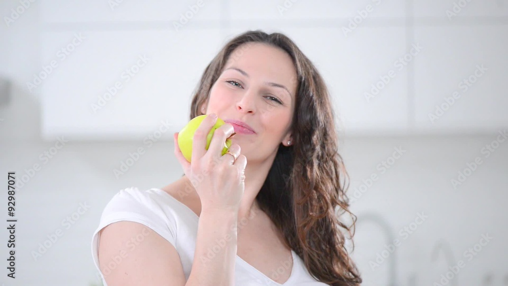 Young smiling pregnant woman eating an apple Young smiling pregnant woman eating an apple