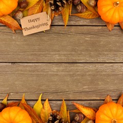 Happy Thanksgiving gift tag with double border of colorful leaves and pumpkins over a rustic wood background
