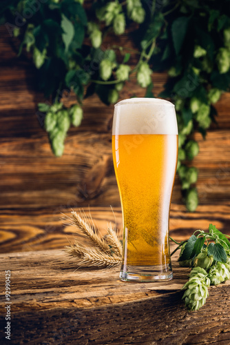 Glass of beer on old wooden table and wooden background