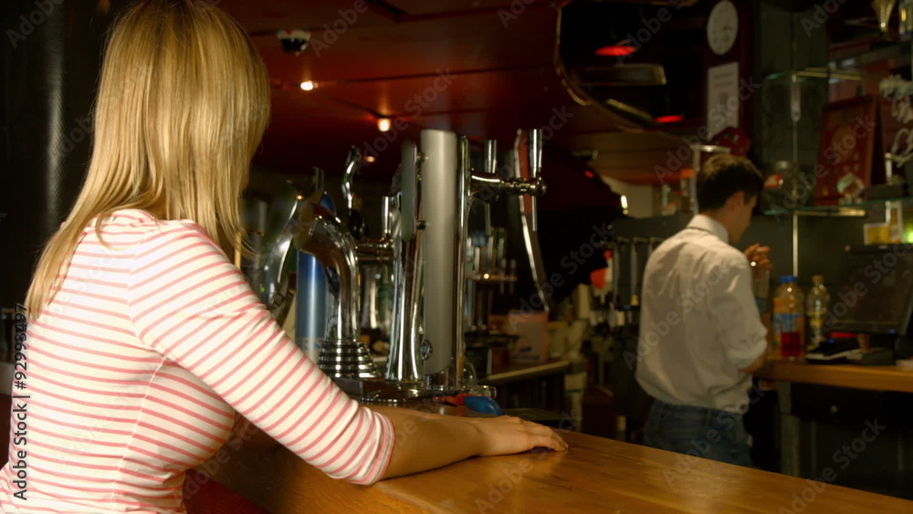 Woman being served drink at the bar Woman being served drink at the bar