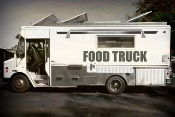 aged and worn vintage photo of black and white food truck