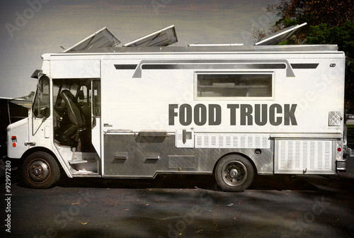aged and worn vintage photo of black and white food truck