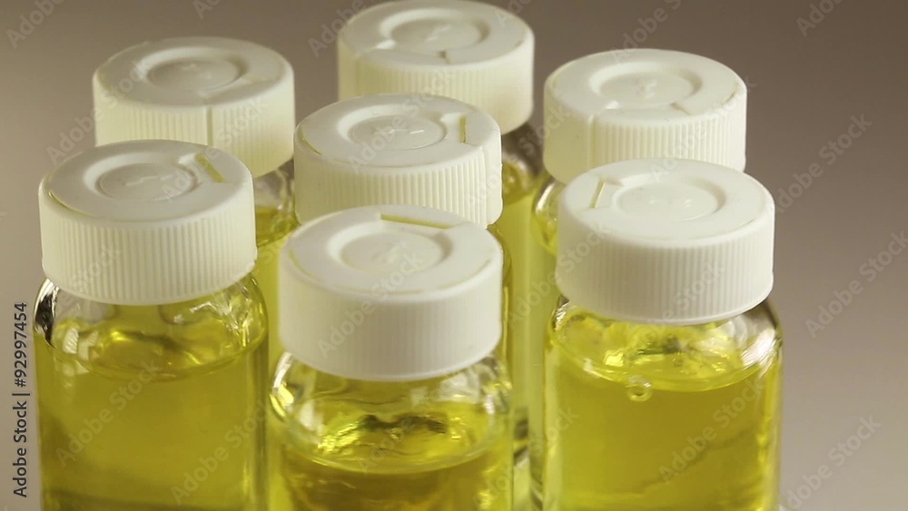 Seven rotating bottles with yellow liquid Seven rotating bottles with yellow liquid